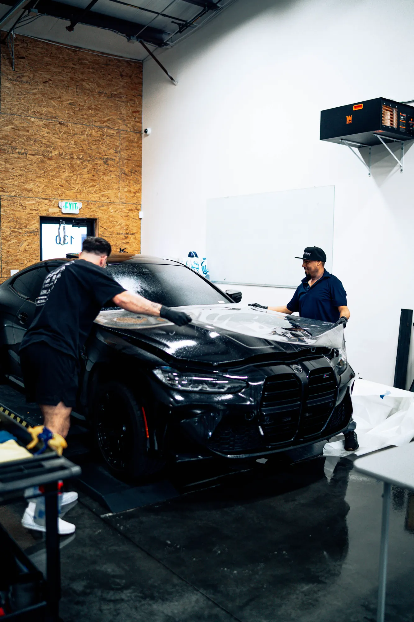 Paint protection film being applied to a hood